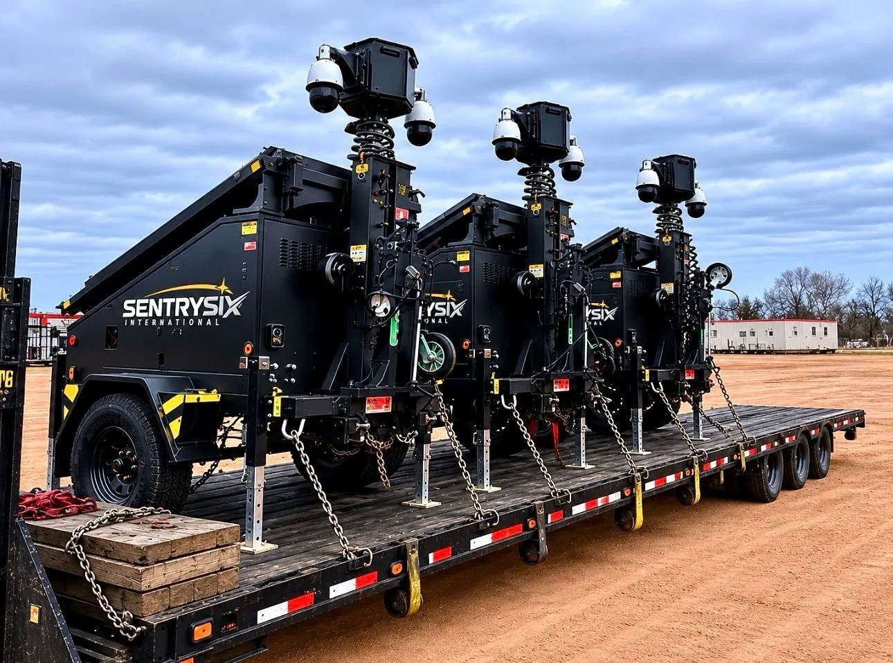 Three black surveillance units on a trailer.